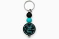Faith Over Fear keychain with black and turquoise beads, a round black charm with turquoise lettering, and a silver-tone key ring.